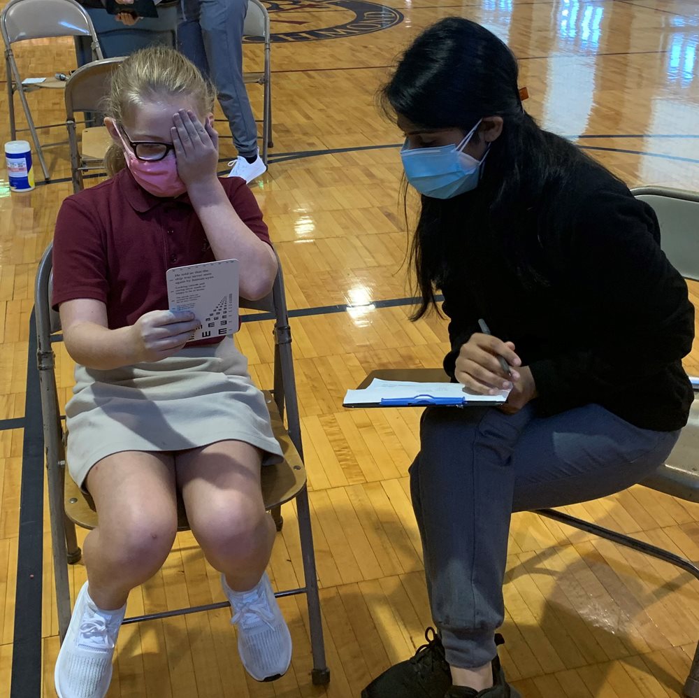 Optometrist giving student vision screening