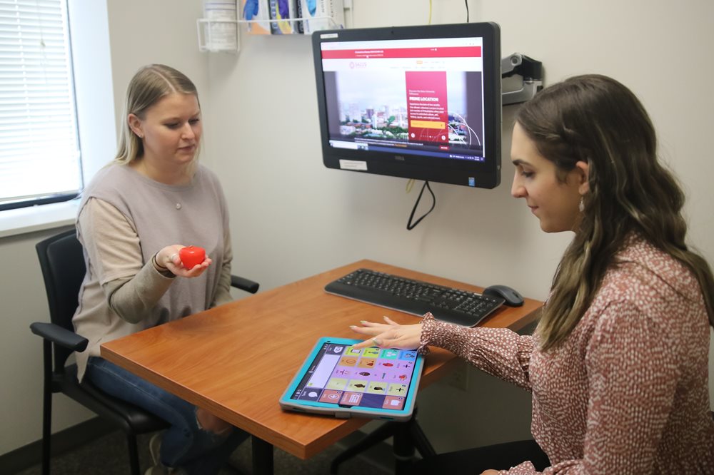 Speech Language Pathologist and patient with tablet