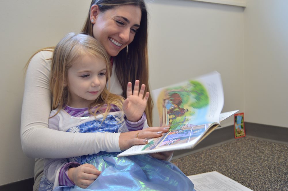 SLP student reading to pediatric SLI client