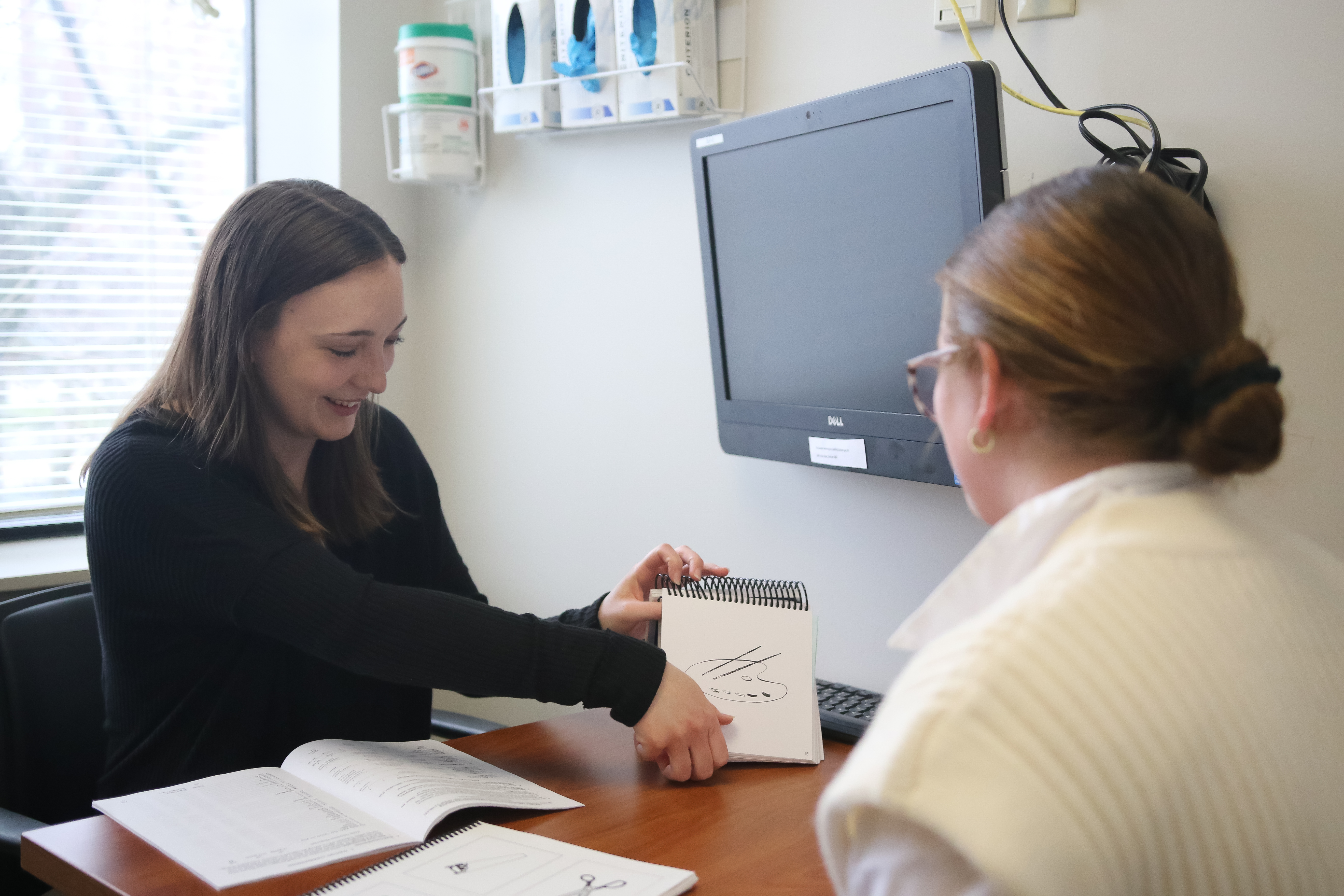 Speech-Language Pathologist going over words with client