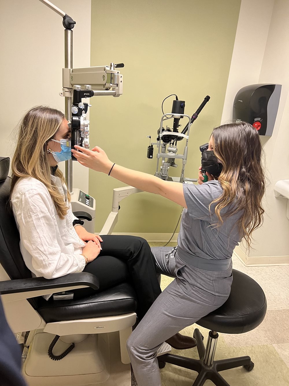 Taylor Frank conducting eye exam on patient