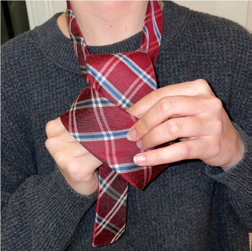 Person tying a tie