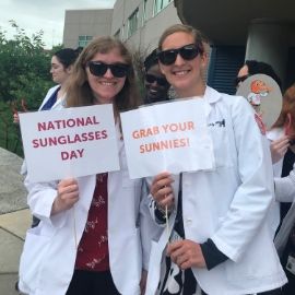 Students wearing sunglasses and holding "National sunglasses day" signs