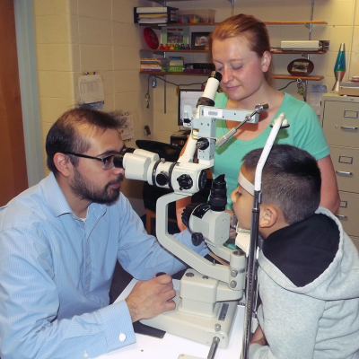 Dr. Trujilo conducting and eye exam on a boy