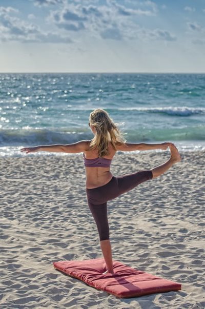 Woman doing yoga on the beach