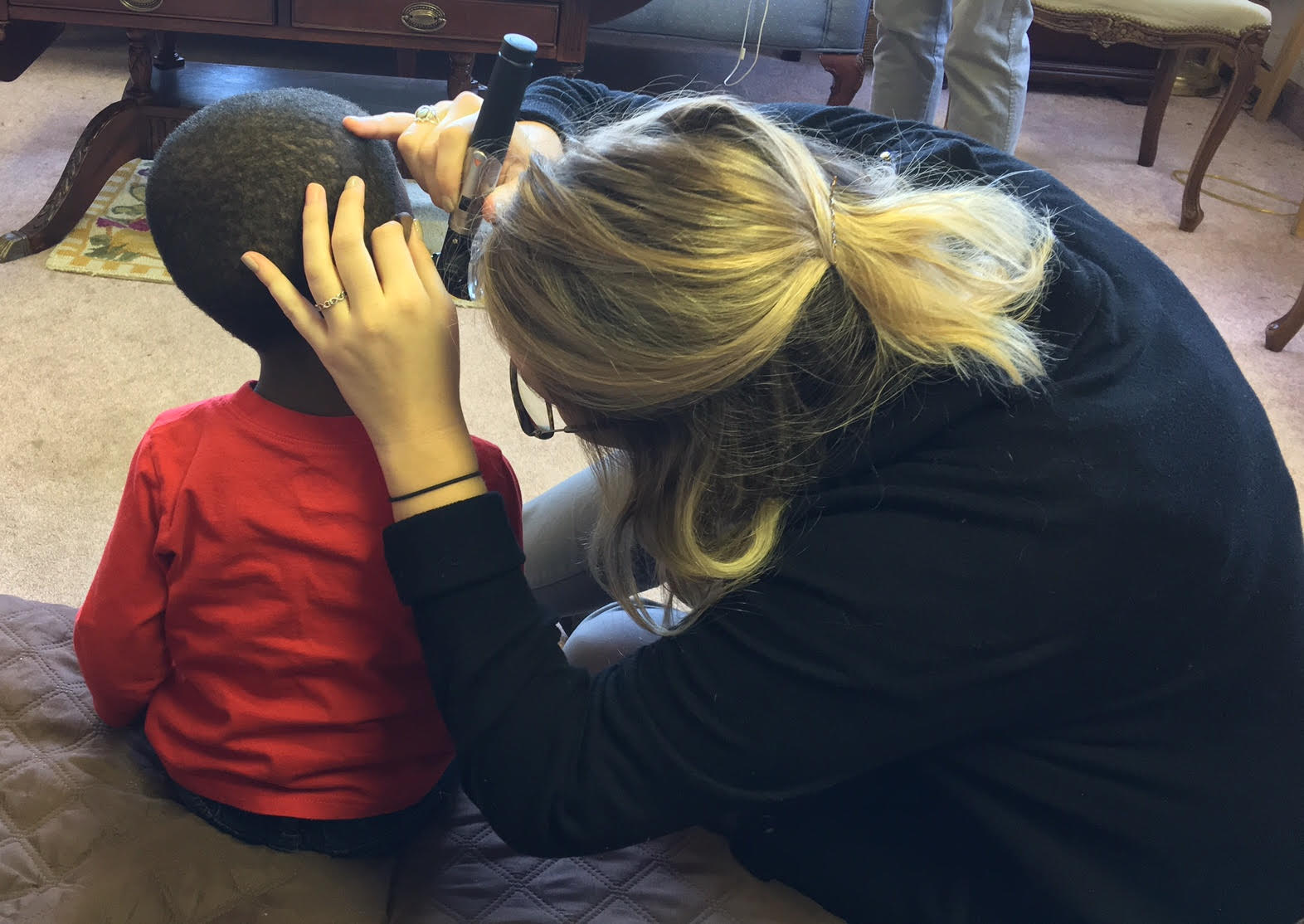 Audiology student examining young boy