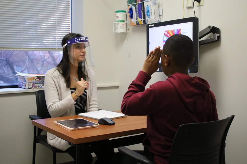 Young boy with speech language pathologist