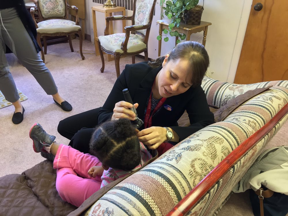 Dr. Bondurant giving an ear exam to a pediatric patient